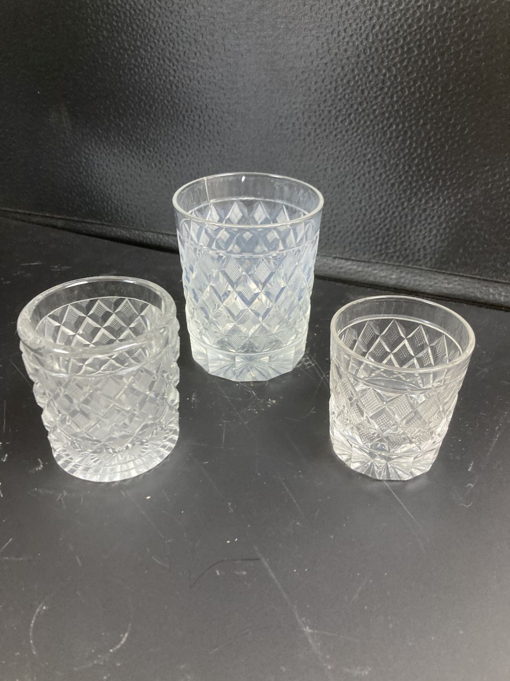 Five cut glass tumblers, the largest with enamelled panels, 13.5cm